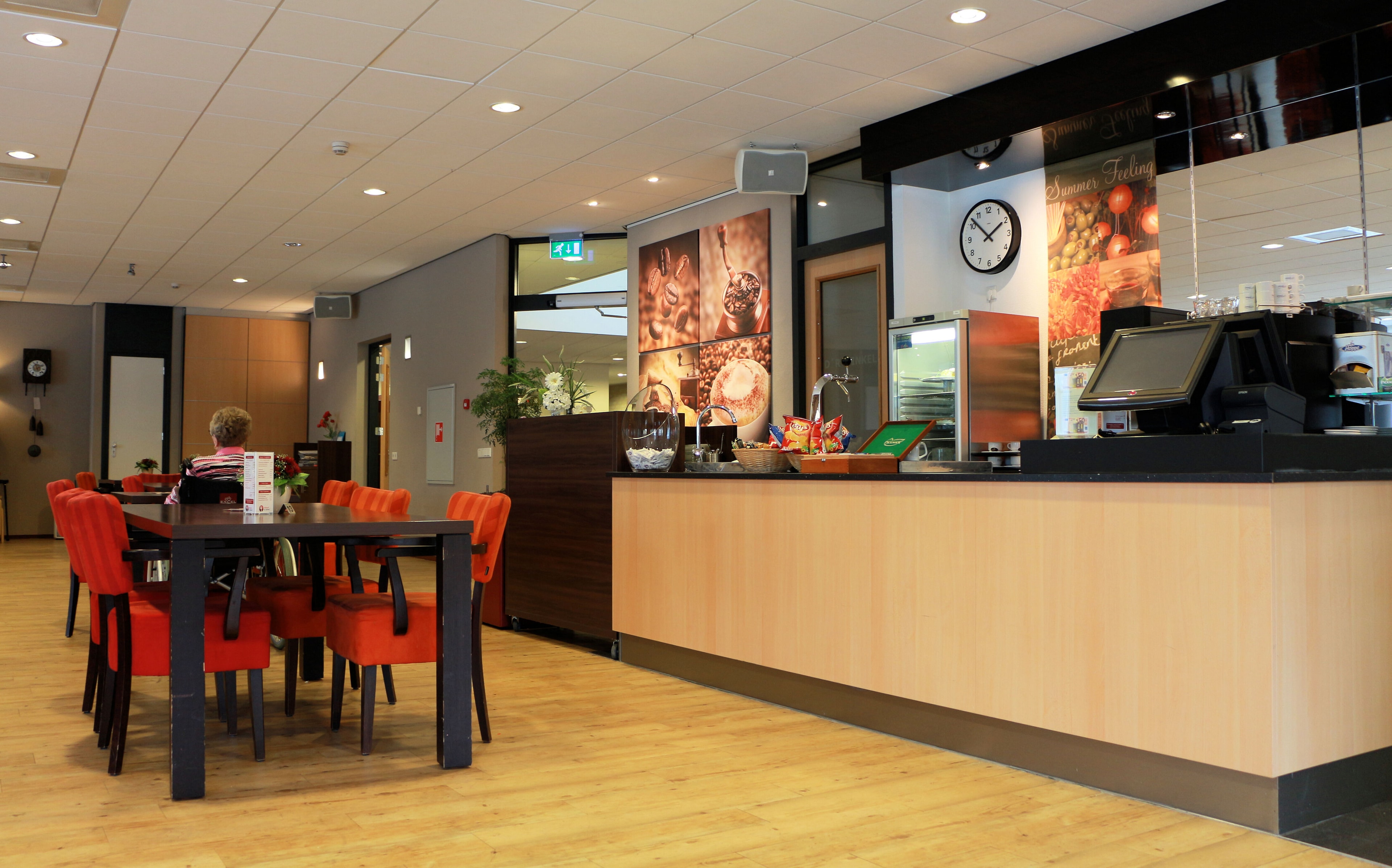 Tafel met stoelen en balie in de horecagelegenheid van Dokter Calshof.